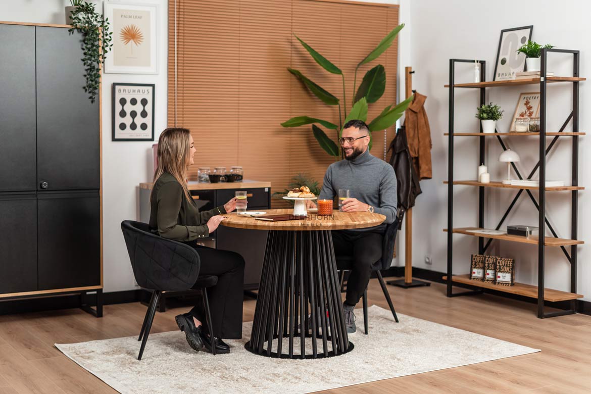 Runder Tisch mit durchbrochenem Metallgestell und Holzplatte