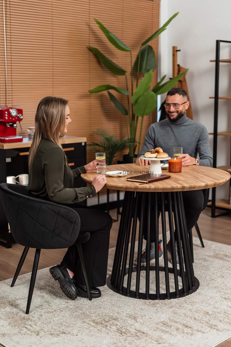 Runder Tisch mit durchbrochenem Metallgestell und Holzplatte