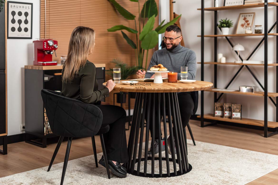 Runder Tisch mit durchbrochenem Metallgestell und Holzplatte
