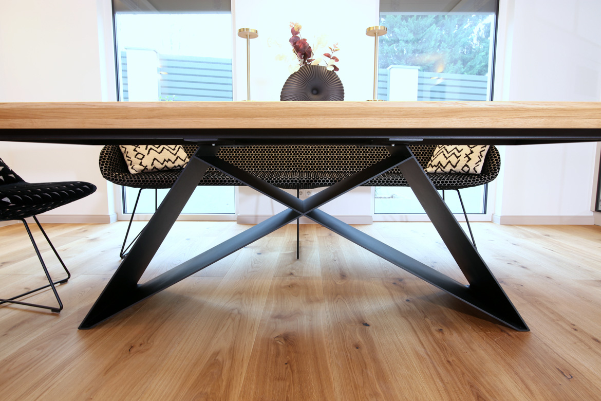 Table de salle à manger en bois avec un plateau massif et un piètement géométrique noir pour un client allemand