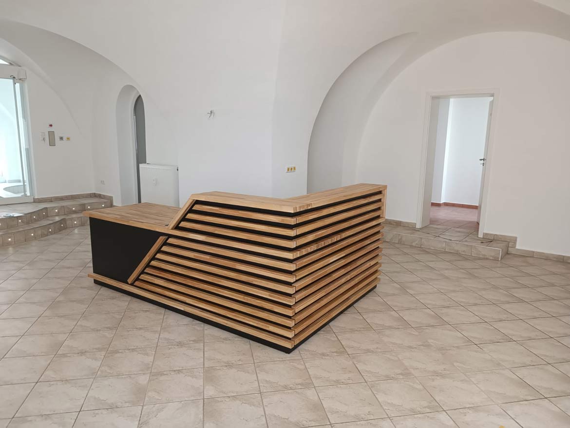 Réalisation pour un client allemand – comptoir d'accueil d'angle gauche avec des lamelles en bois