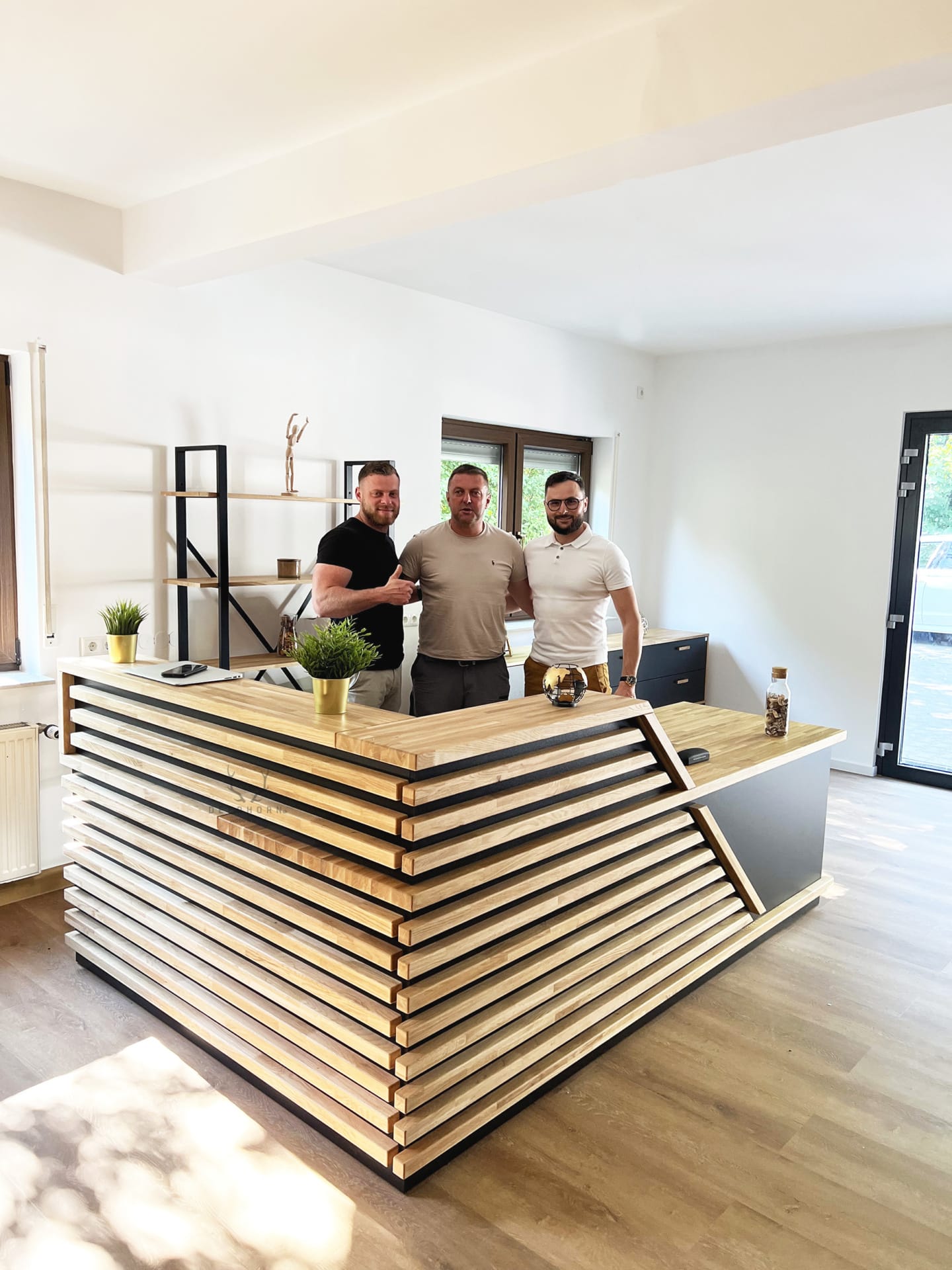 Comptoir d'accueil d'angle noir à lamelles – surprenez vos clients avec un comptoir d'accueil unique